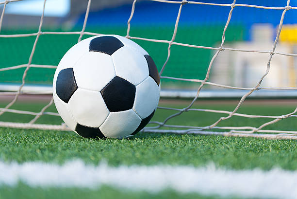 istock Football ball against goal net 514674985