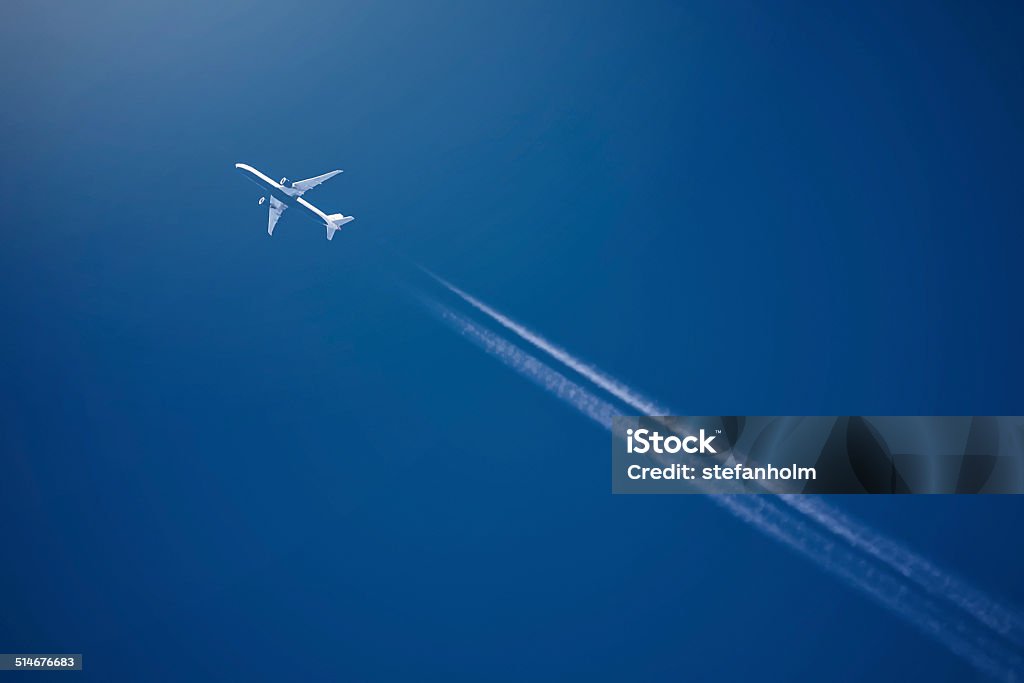 Airliner at high altitude with white condesation trails Airliner at high altitude with white condesation trails, on deep blue sky Airplane Stock Photo
