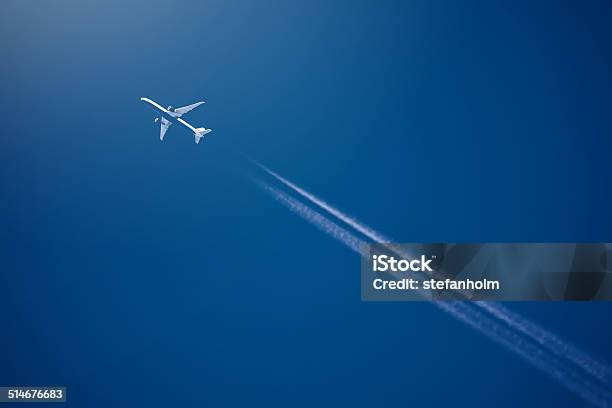 Airliner At High Altitude With White Condesation Trails Stock Photo - Download Image Now