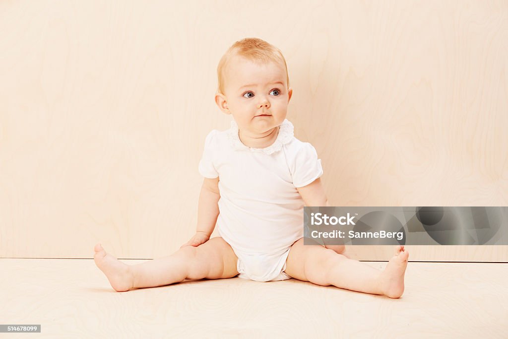 Baby girl looking up, studio shot Infant Bodysuit Stock Photo