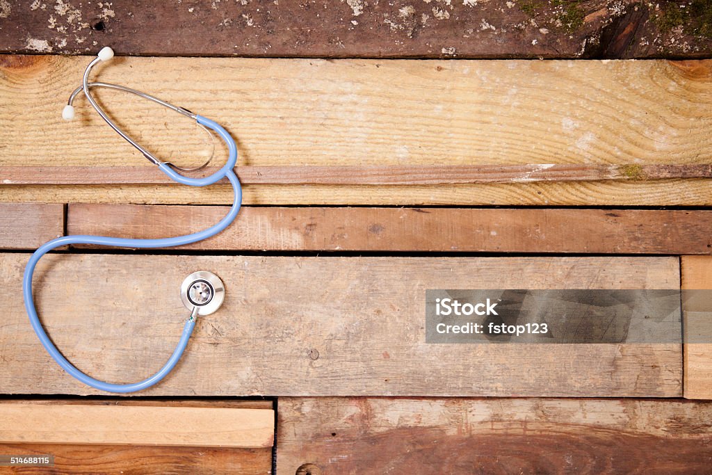 Doctor's stethoscope on unique wooden table. Nobody. Backgrounds. Medical background.  Overhead view of doctor's stethoscope.  Unique wooden table, boards background.  Beige Stock Photo