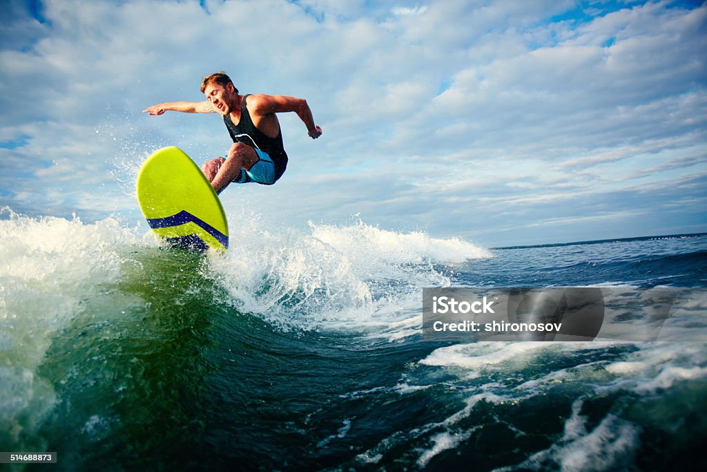 Surfing Male surfer riding on waves in the sea Surfing Stock Photo