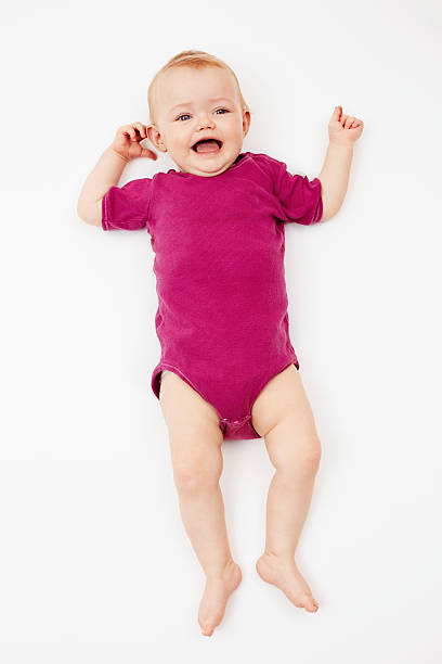 Baby girl lying against white background