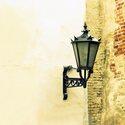 Vintage street lamp against old wall background. Riga, Latvia