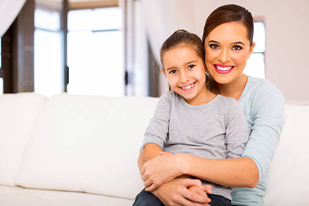 istock young woman sitting on couch with her daughter 514710870