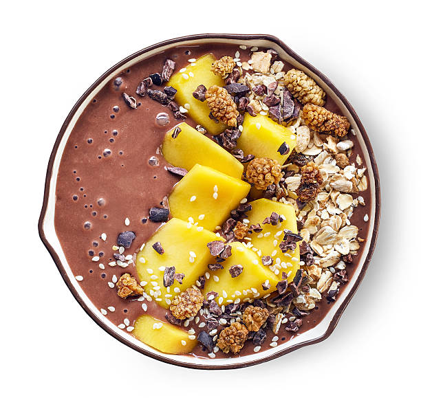 breakfast smoothie bowl breakfast banana and chocolate smoothie bowl topped with mango and superfoods cacao nib stock pictures, royalty-free photos & images