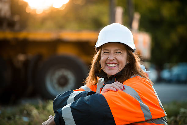 szczęśliwy w pracy-starszy kobieta inżynier - construction safety protective workwear hardhat zdjęcia i obrazy z banku zdjęć
