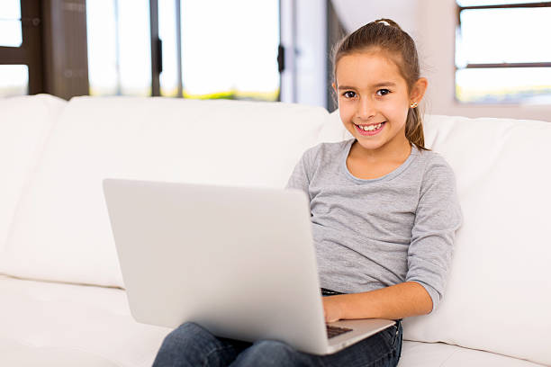 istock little girl using laptop on sofa 514714168