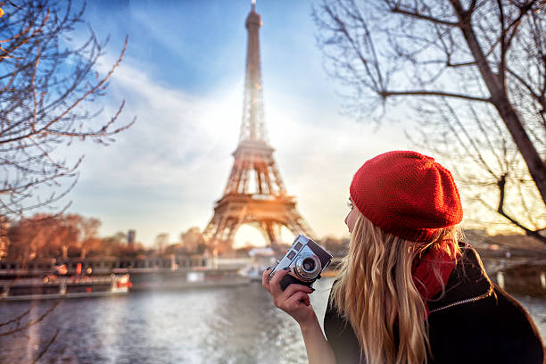 traveling and lifestyle concept.tourist woman with red beret admiring the Eiffel tower and holding camera in her hand.