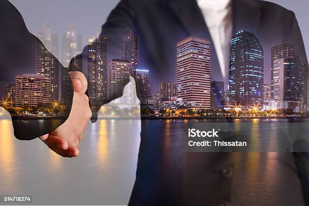 Double Exposure Of Handshake Night City Urban And Lake Stock Photo - Download Image Now