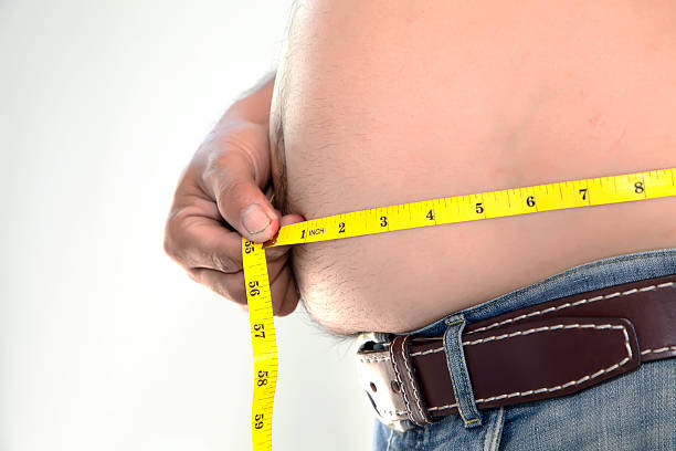 fettleibig person messen seinen bauch. - pot belly stock-fotos und bilder