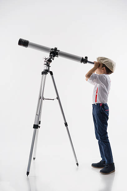 Young boy with astronomy telescope,studio