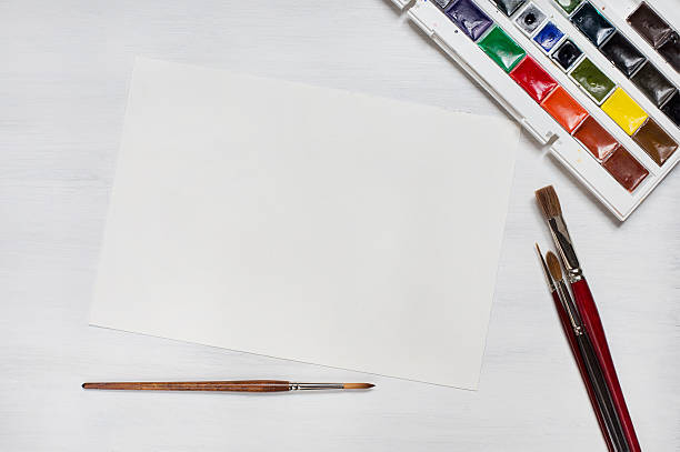 istock Different watercolor paintbrushes with colors and paper 514722348