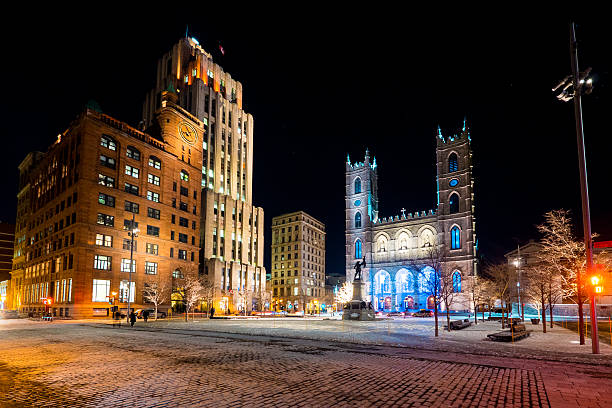 Place d'Armes and Notre-Dame Basilica View of Place d'Armes and Notre-Dame Basilica and a few people walking around in winter at night in Montreal, Canada. place darmes montreal stock pictures, royalty-free photos & images