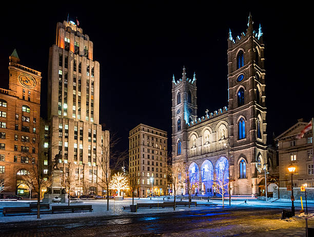 Place d'Armes and Notre-Dame Basilica View of Place d'Armes and Notre-Dame Basilica and a few people walking around in winter at night in Montreal, Canada. place darmes montreal stock pictures, royalty-free photos & images