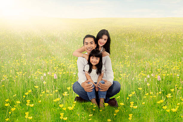 istock Cheerful family sitting on meadow at springtime 514724080