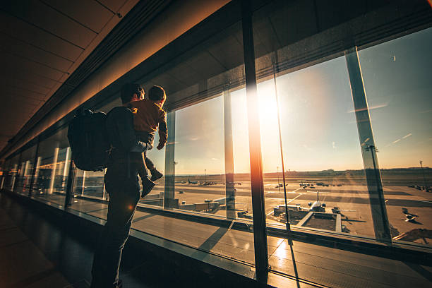 While waiting... Young man and his son looking out of the window while waiting on airport lounge travel destinations family stock pictures, royalty-free photos & images