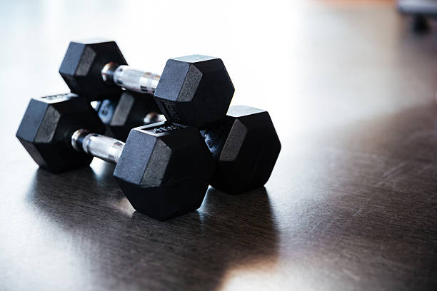 istock Three metal dumbbells on the floor in gym 514726560