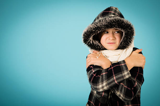 Color image of a brown-haired little girl trying to stay warm on cold winter day. Includes room for your text.