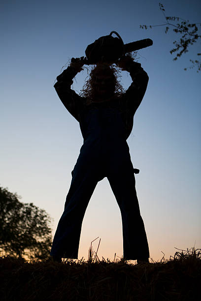 Silhouette of a Scarecrow holding a chainsaw