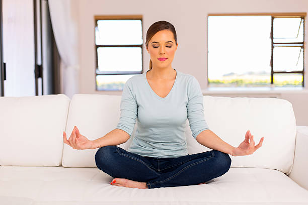 istock woman meditation on couch 514726860