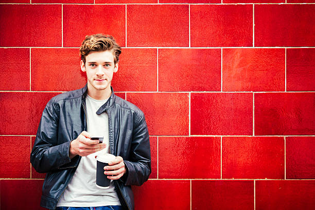 istock Young British man portrait against red wall 514727045