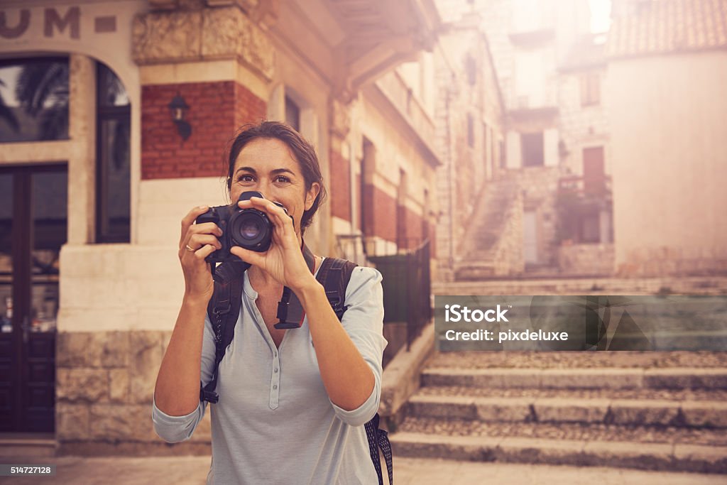 One vacation, so many memories Shot of a woman taking photos while exploring a foreign city Women Stock Photo