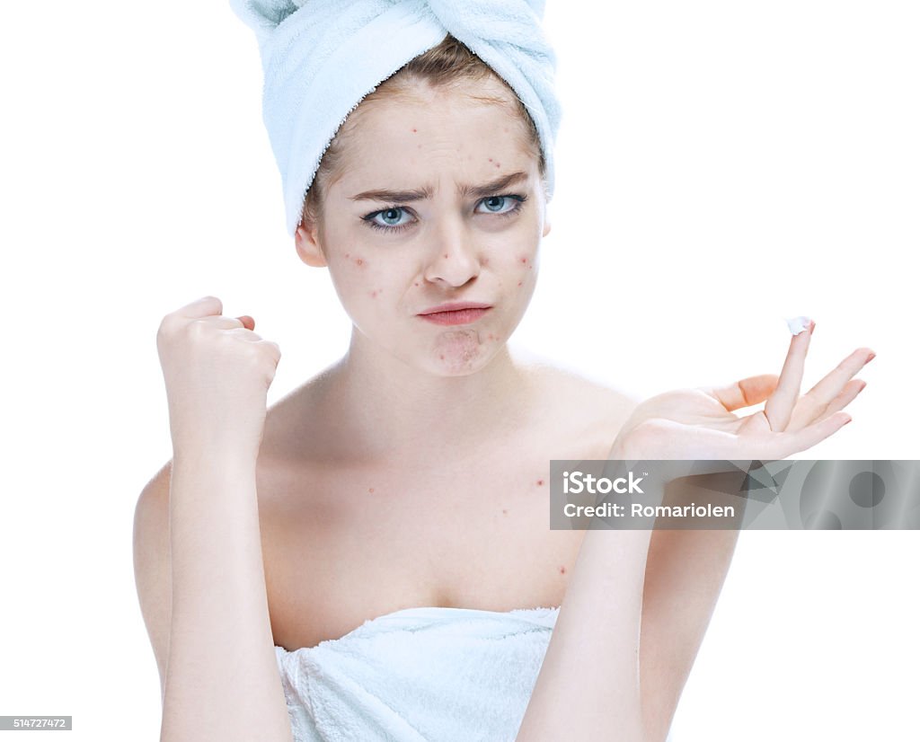 Scowling girl in shock of her acne Scowling girl in shock of her acne with a towel on her head. Woman skin care concept / photos of european girl on white background Acne Stock Photo