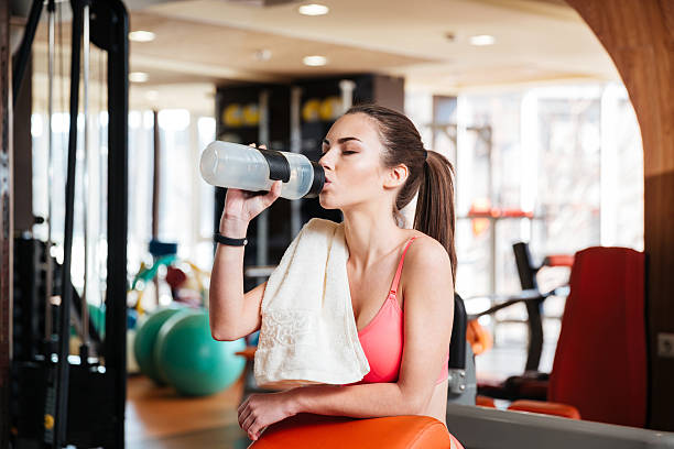 istock Woman athlete drinking water on training in gym 514729028