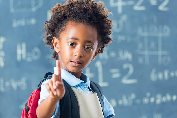 cute african american prywatne szkoły dziecko trzymając jeden palec - african descent child brown eyes ethnicity zdjęcia i obrazy z banku zdjęć