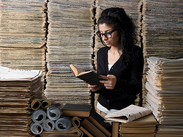istock Mixed race female student reading book in library 514731353