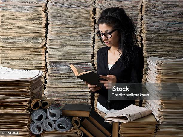 Mixed Race Female Student Reading Book In Library Stock Photo - Download Image Now - Research, Newspaper, Stack