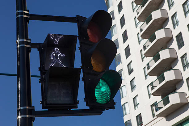 Green Traffic Light and walk sign With Building in the Background