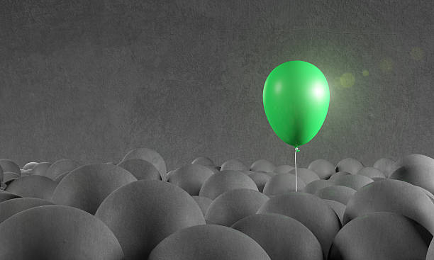 istock Green balloon rising from gray background: individuality, standing out 514732348