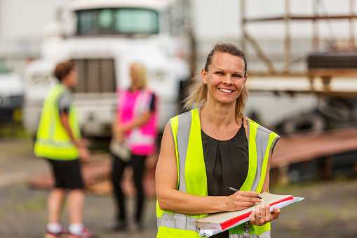 Empowered happy women working in the transport industry wearing high visibility clothing