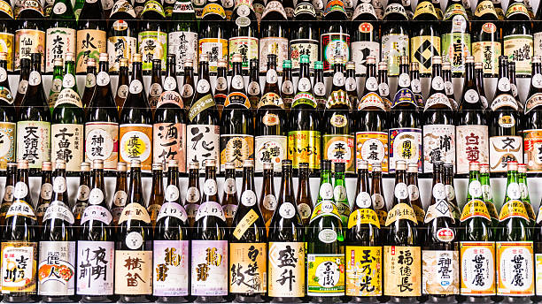 Sake Collection Large collection of Japanese sake bottles with multiple colored labels arranged on shelfs taken at temple in Tokyo. saki photos stock pictures, royalty-free photos & images
