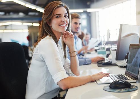 Cropped portrait of a young businesswoman working in the office with her colleagues