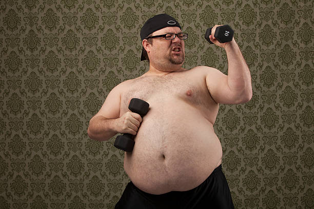 istock shirtless, overweight male excerses with weights 514755783