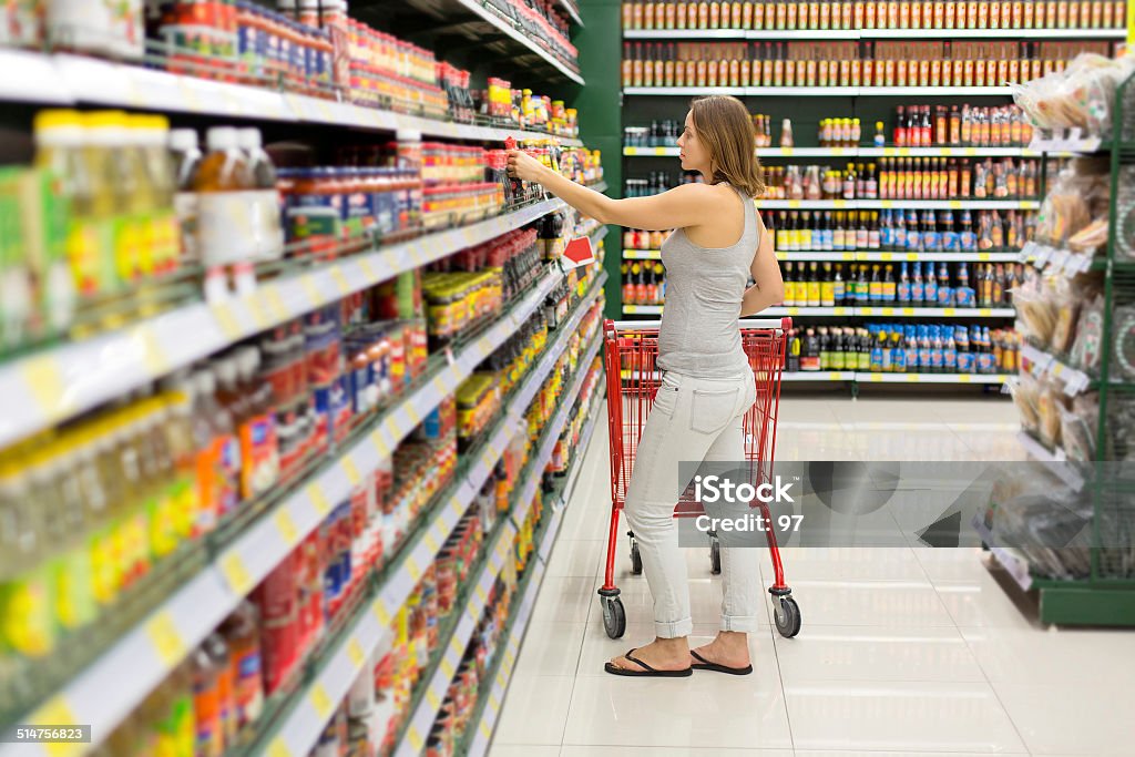 woman chooses sauce in the supermarket Savory Sauce Stock Photo