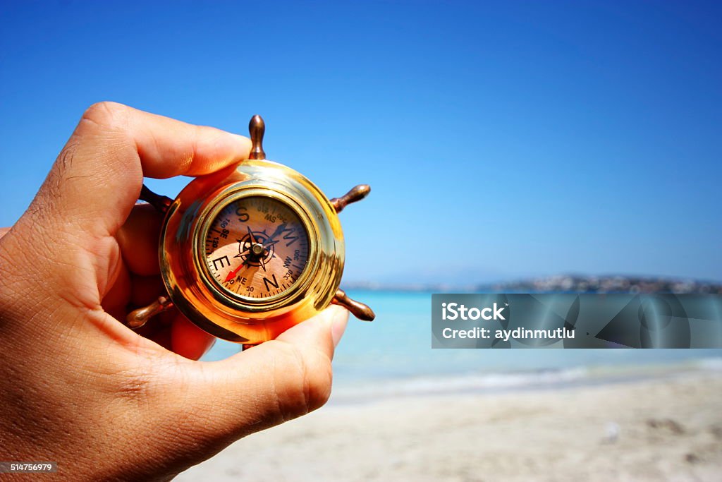 Hand Holding Compass Hand Holding Compass on sea. Navigational Compass Stock Photo