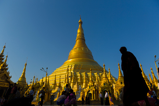 Yangon,  Myanmar  - February 12, 2016: Yangon,  Myanmar - February 12, 2016: Buddhist monk walking around the Beautiful Shwedagon Pagoda, a gilded pagoda and stupa 99 metres in height that dominates over Yangon. It is the most sacred buddhist pagoda in Myanmar and the world.