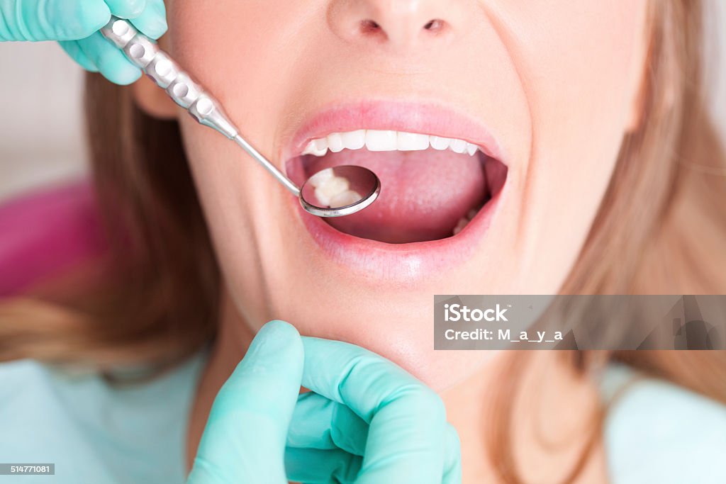 Patient visiting dentist Female patient with open mouth  receiving dental inspection at dentist's office Dentist Stock Photo