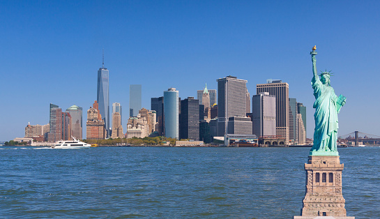 Downtown Manhattan and the Statue of Liberty, New York City. The New World Trade Center towers are in the left part of the image and Brooklyn Bridge is on the right in background.