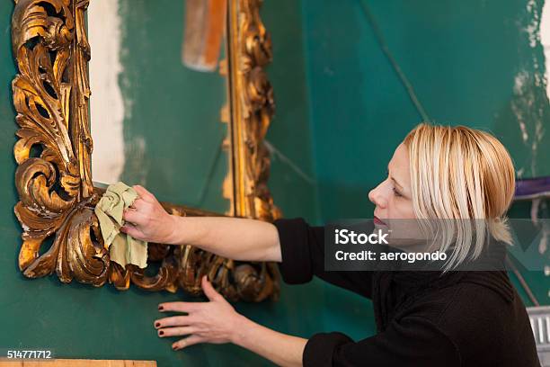 Woman Cleaning A Mirror In Preparation For Auction Stock Photo - Download Image Now - Gold Colored, Mirror - Object, Old-fashioned