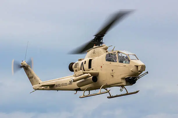 An AH-1 Cobra gunship hovering over the ground.  Armed with 2.5 inch rockets and a chain gun, the Cobra served with the US Army for decades.