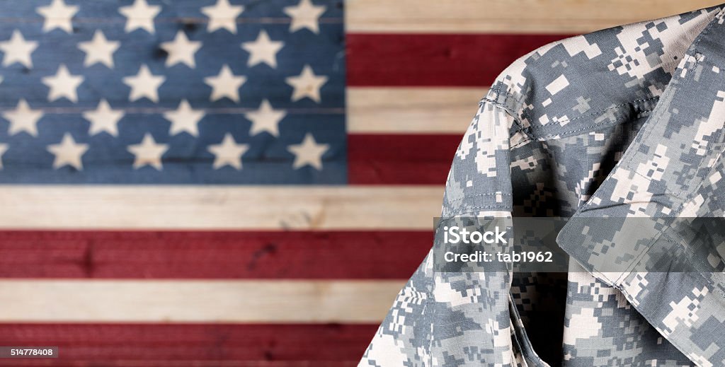 Military uniform with faded boards painted in American USA flag Close up of military uniform with painted rustic boards of USA flag in background. USA Stock Photo
