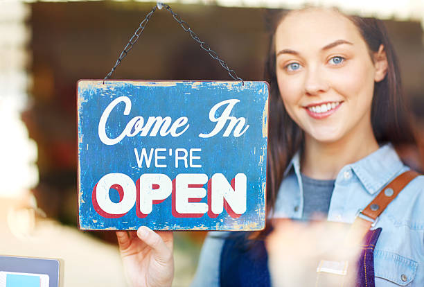 istock Happy florist turning open sign at shop window 514779144