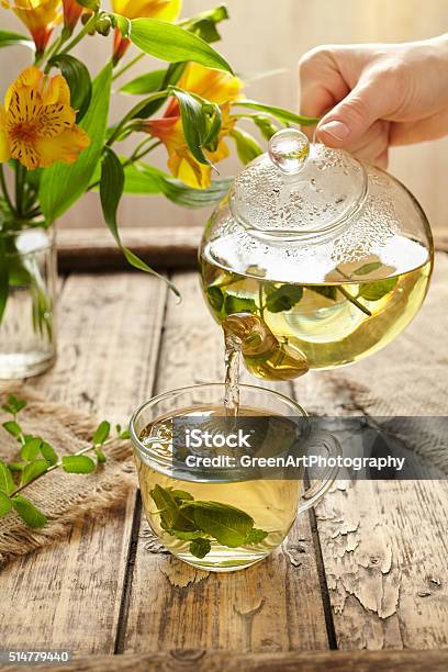 Sage Tea Pouring In Glass Transparent Cup From Teapot Stock Photo - Download Image Now