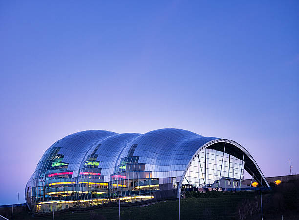 Newcastle, UK - February 10, 2016: A view from across the River Tyne of The Sage Gateshead, illuminated by coloured lights within the building. The public building for musical education and performance, situated on the south bank of the River Tyne was opened in 2004.