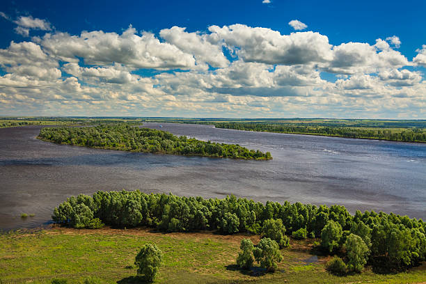 The picturesque landscape with big river under the white clouds.